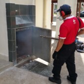 Technician fogging a rubbish chute for mosquito and pest control